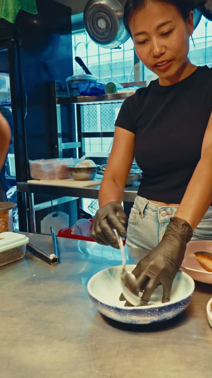 A cook plating a bowl